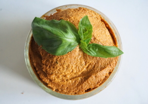 Zonnebloempitten spread met zongedroogde tomaat en basilicum