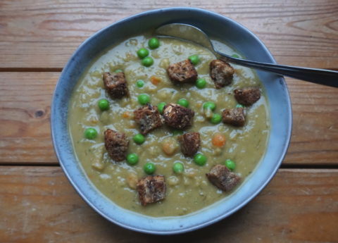 Rokerige vegan erwtensoep (snert) met doperwten, wortelen en knoflook croutons