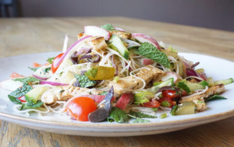 Zomerse vegan mihoensalade met tofu, perzik, tomaat, komkommer, augurk en munt