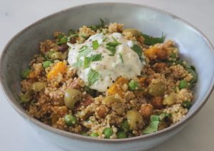 Vegan quinoa salade met pompoen, kikkererwten, doperwten , noten en amandelyoghurt